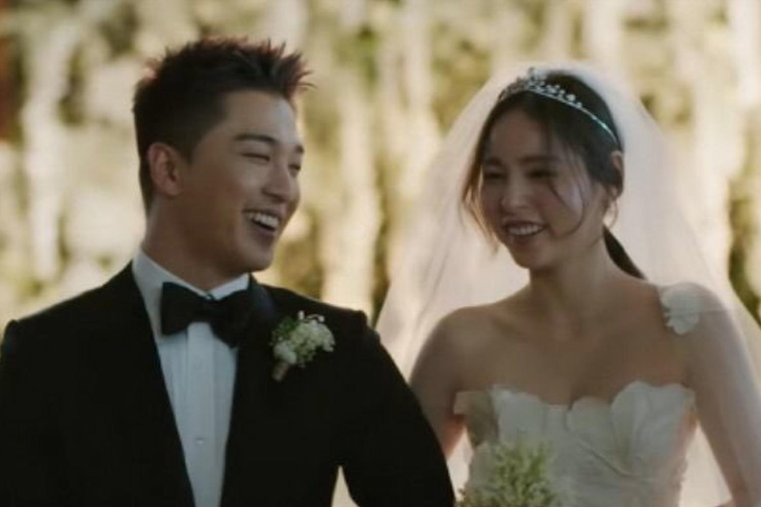 婚禮現場照片，新郎和新娘親密地挽著手臂，背景是綴滿花朵的典雅場地，新娘穿著婚紗和頭紗。