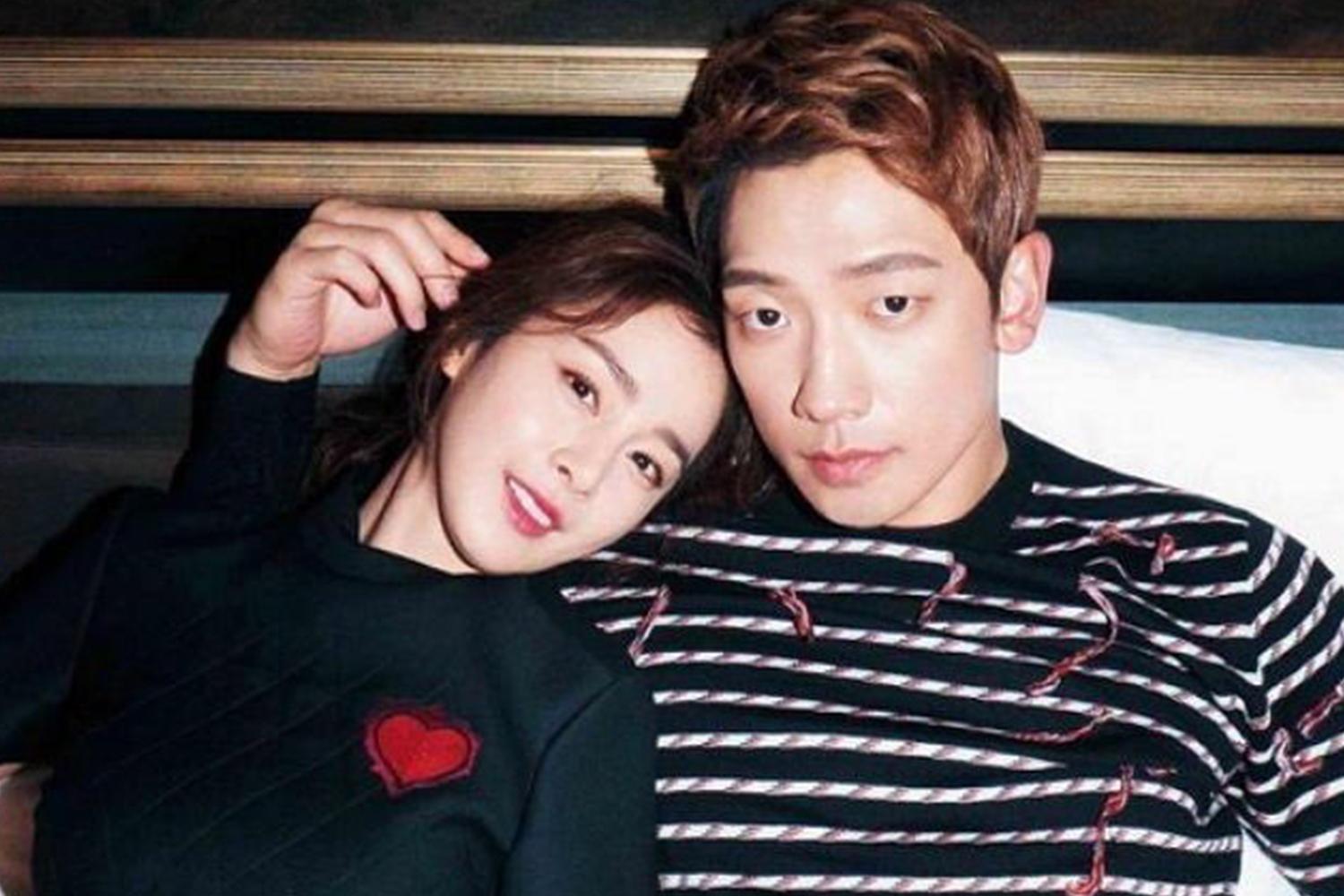 韓國明星情侶合影，兩人親密地依偎在牀上，男方穿著橫條紋襯衫，女方長髮披肩，背景是牀頭板。