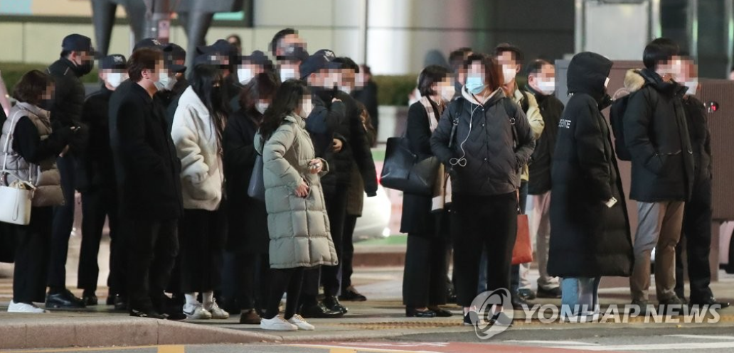 韓国の寒い朝、ソウルで厚着をして出勤する人々の様子。厚手のコートを着ている人が多く、気温の低下を物語っています。
