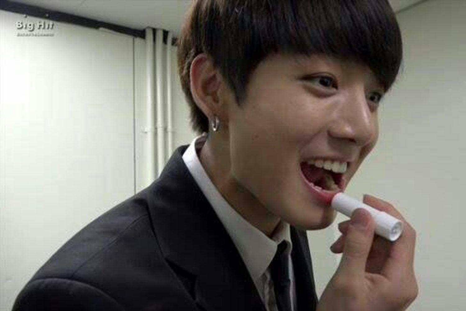 Người bôi son dưỡng môi, với son dưỡng bảo vệ viền môi.