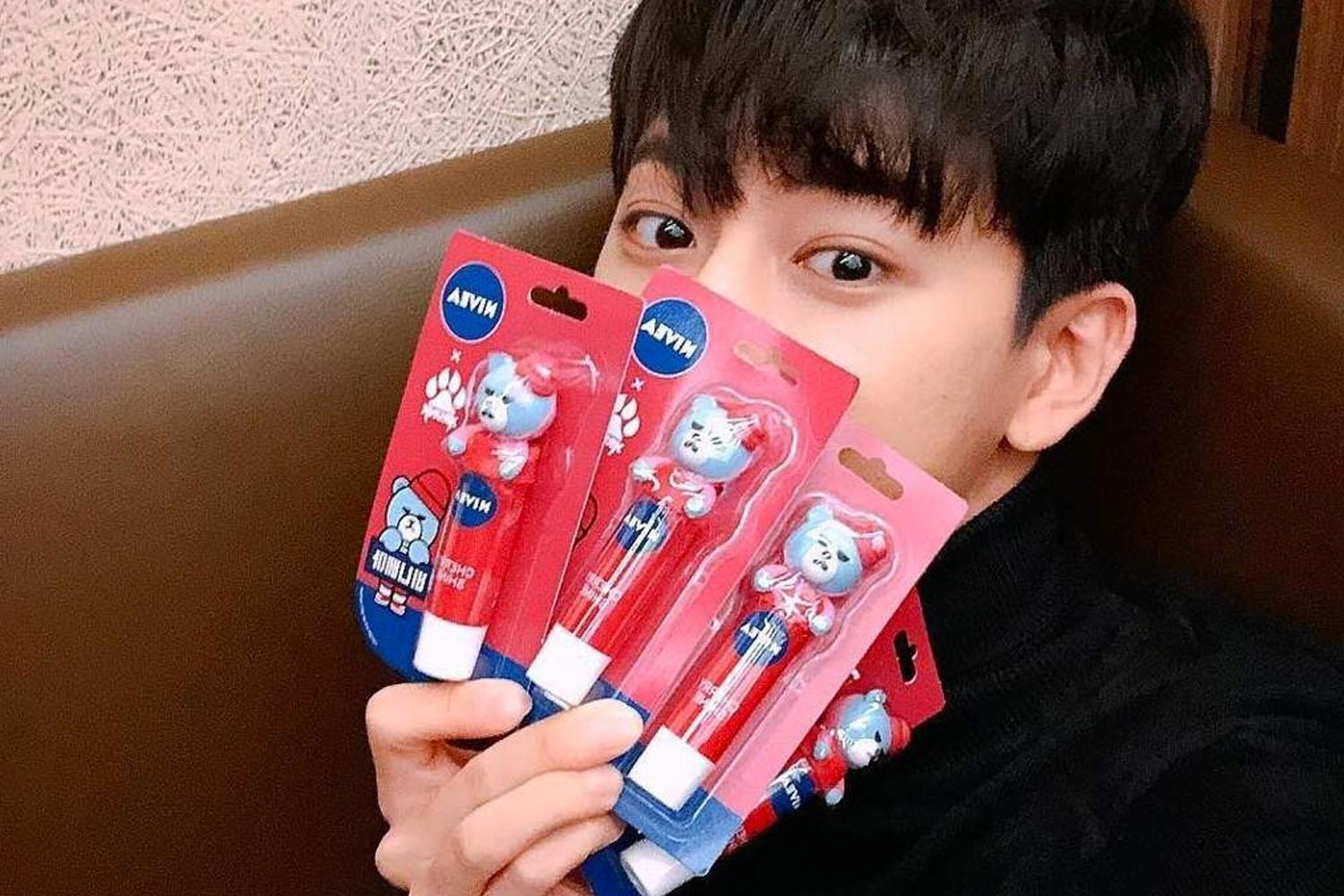 Một người cầm lên nhiều thỏi son dưỡng Nivea, thể hiện sự lựa chọn các sản phẩm chăm sóc môi.