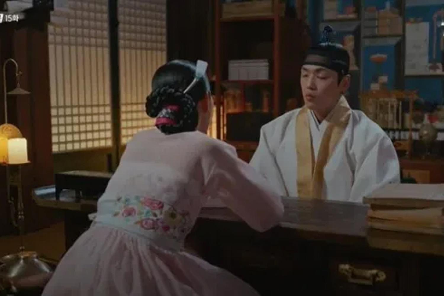 ฉากจากซีรีส์ที่หญิงสาวแต่งชุดฮันบกคุยกับชายในห้องสไตล์เกาหลีดั้งเดิม