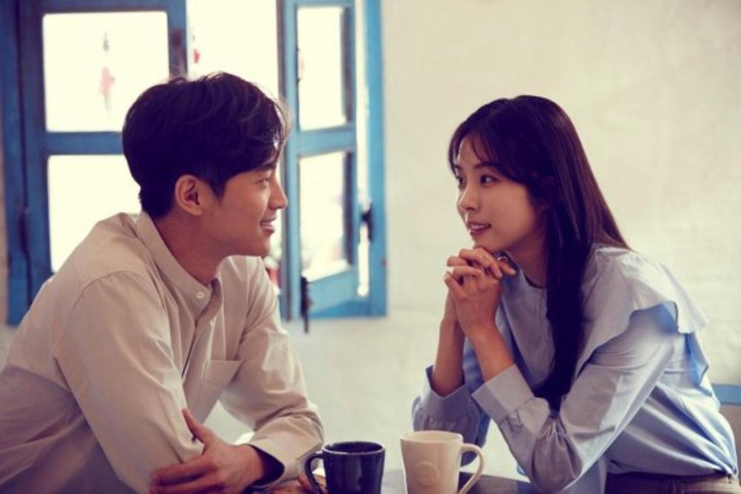 คู่รักนั่งคุยกันในคาเฟ่สไตล์เกาหลี, มีถ้วยกาแฟวางอยู่บนโต๊ะ
