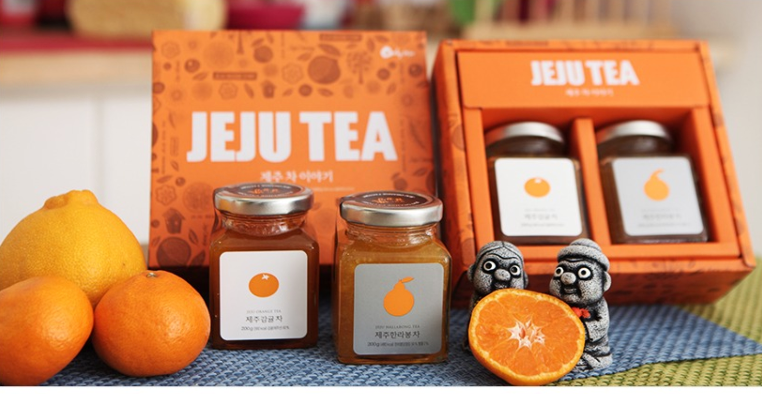 香港中環濟州島香橙醬展示,裝有不同口味的果醬,並排列整齊,背景為色彩豐富且繽紛的布料和水果裝飾。