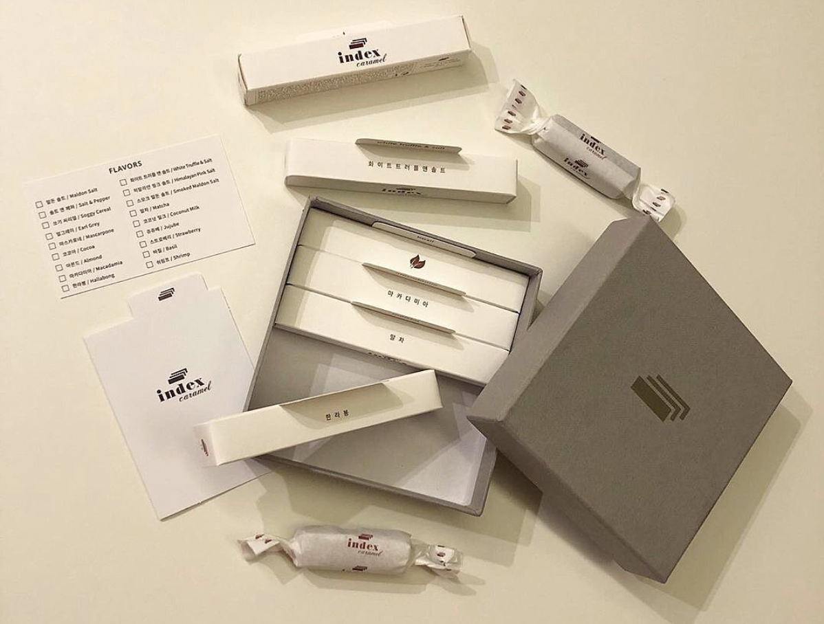 香港中環精緻牛奶糖禮品展示圖,展示糖果紙含有多種口味選擇,背景為米色桌面且細膩擺設。