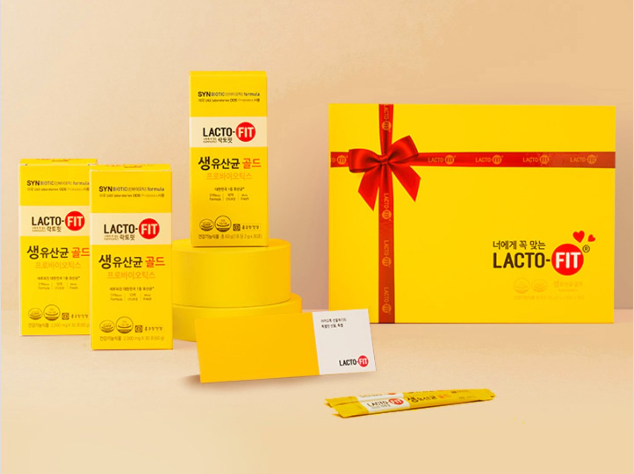 香港中環鐘根堂Lacto-Fit益生菌限量禮盒展示,展示益生菌包裝以及禮盒,背景為黃色,並有紅色的蝴蝶結。
