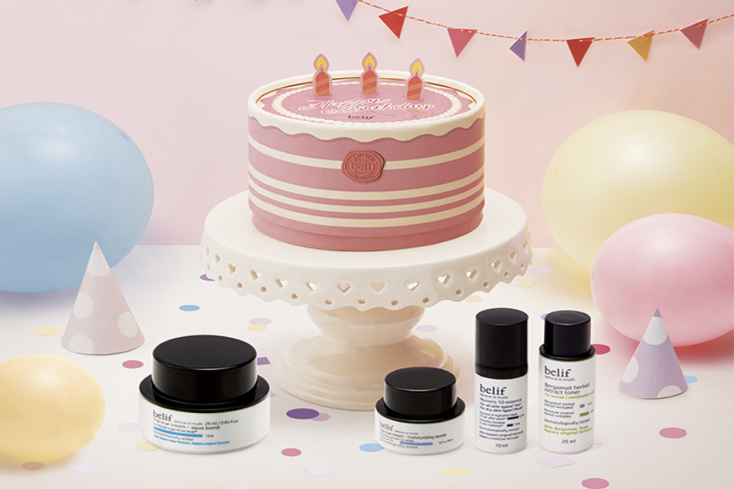 香港中環belif水分霜生日組合展示圖,包含裝飾有生日蠟燭的大型生日模型蛋糕和產品,背景以粉色點綴。
