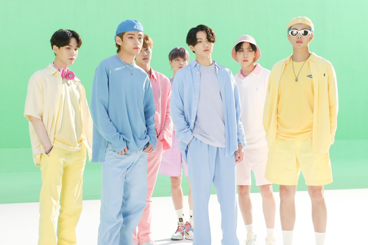 BTS成员穿着色彩鲜艳的服装站在绿色背景前