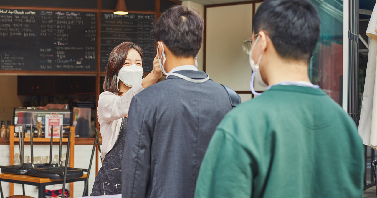 進入咖啡廳前檢查體温的韓國人，展示疫情期間的防疫措施