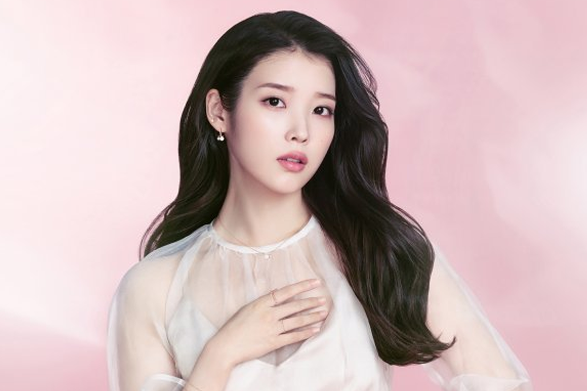 韓國女明星伏在桌上,身著白襯衫,背景為室內的一部分,呈現出慵懶且舒適的氛圍。