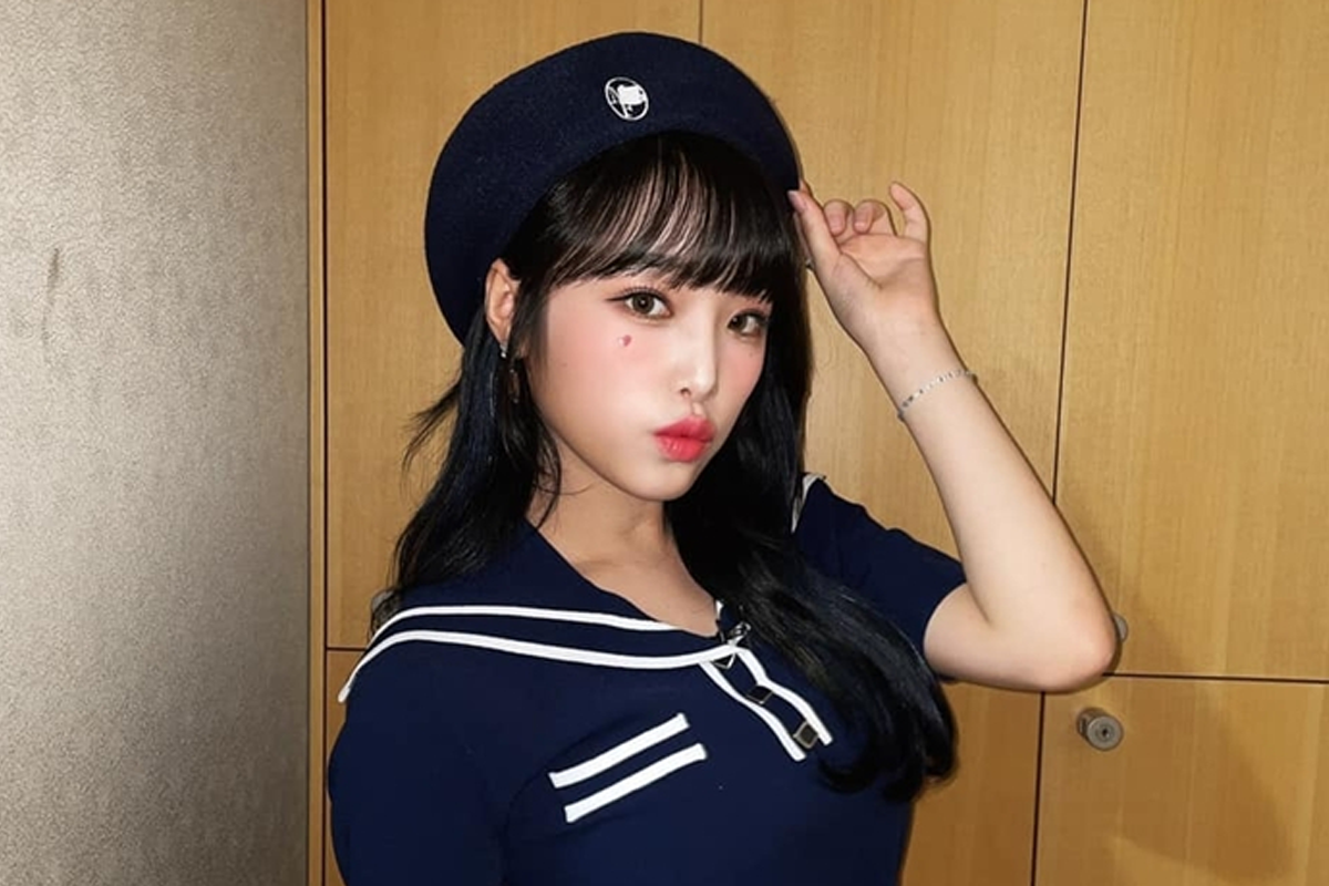 韓國女明星身著白色襯衫,坐在桌子前,靠著手撐著腦袋,呈現出慵懶自然的風格。