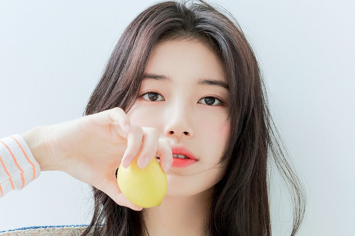 韓國女明星依靠著牆壁,身著自然風姿的長髮,背景為白色欄杆,展現的起初散發著優雅氣質。