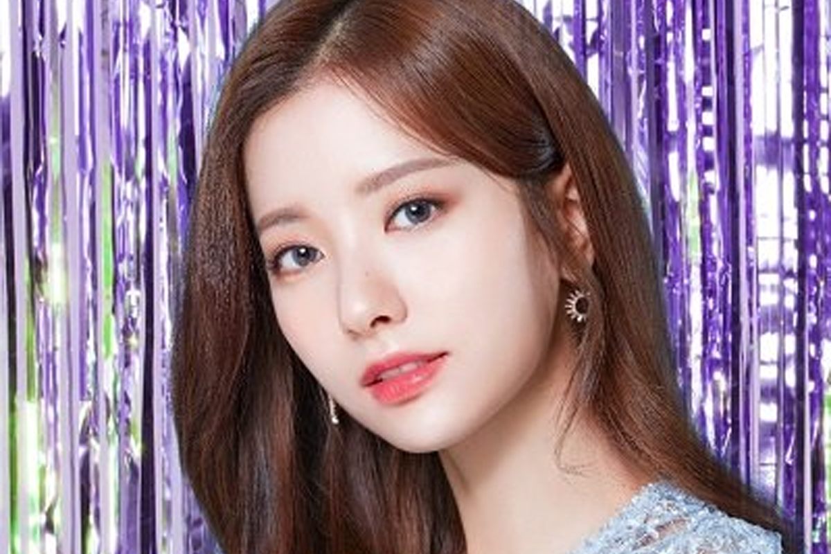 韓國女明星身穿白襯衫搭配珍珠耳環,背景為桃紅色,展現優雅與純潔的魅力。