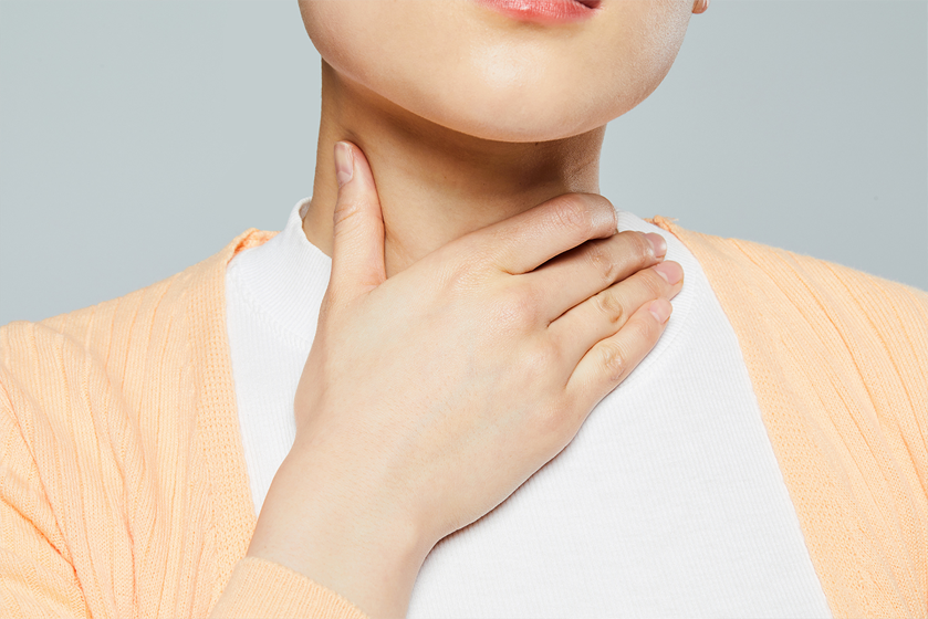 女人因魚刺卡在喉嚨而感到不適，展示了韓國家庭處理食物卡在喉嚨時的傳統做法。