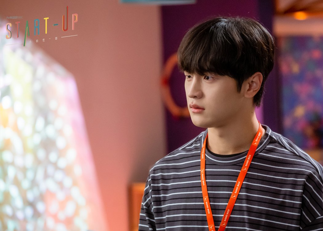 《Start-Up：我的新創時代》中角色穿著條紋襯衣，站在色彩鮮艷的創意工作空間中。