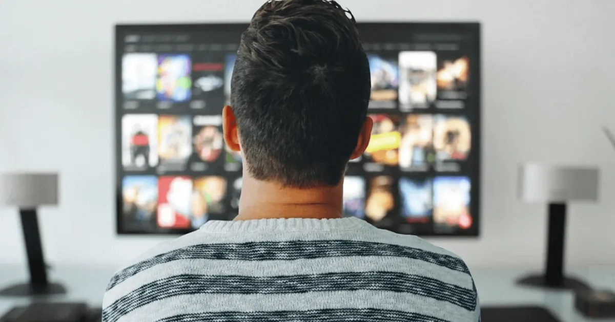 韓劇APP及觀看平臺介紹中的一部人背對電視並拿著遙控器的圖像