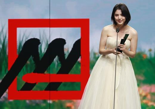 アジアアーティストアワード2020で受賞の栄冠を獲得した女優。華やかなドレスを着用し、ステージでスピーチを行う姿。