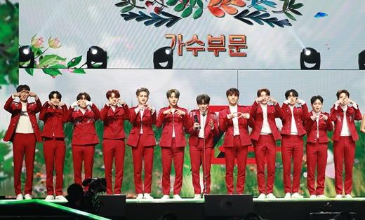 アジアアーティストアワード2020での韓国の新人男性アイドルグループTREASURE。メンバーは揃いの赤い衣装をまとい、ステージで整列している姿。