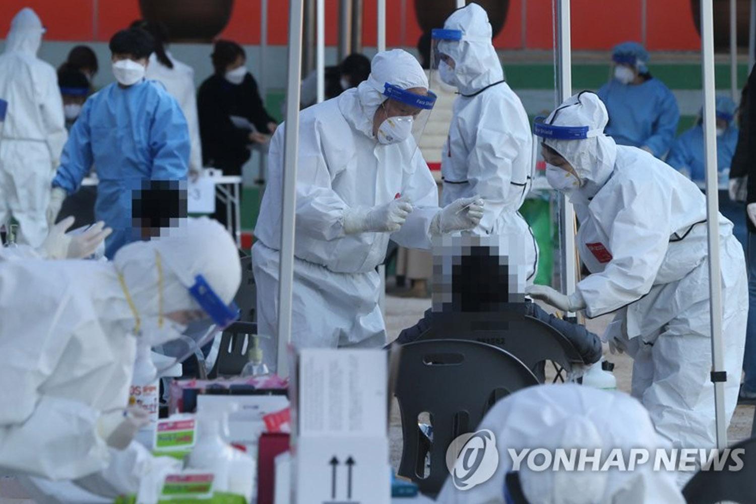 บรรยากาศในสถานที่เก็บตัวอย่างและตรวจสอบการติดเชื้อ COVID-19 ในเกาหลีใต้ที่เต็มไปด้วยเจ้าหน้าที่ในชุดป้องกันสีขาวและฟ้า เพื่อป้องกันการแพร่กระจายของไวรัส โควิด-19 ยังคงระบาดในประเทศ ในภาพมีเจ้าหน้าที่กำลังทำงานตรวจสอบประชาชนอย่างขยันขันแข็ง