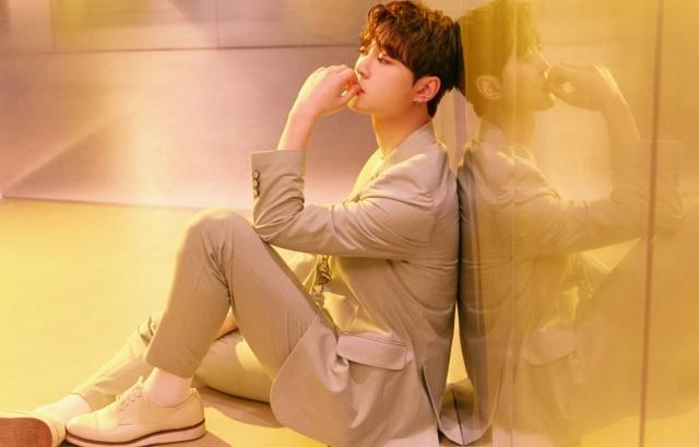 UP10TIONメンバー日常の撮影。あるメンバーが暖色のライトの空間に背を向けて座っている。