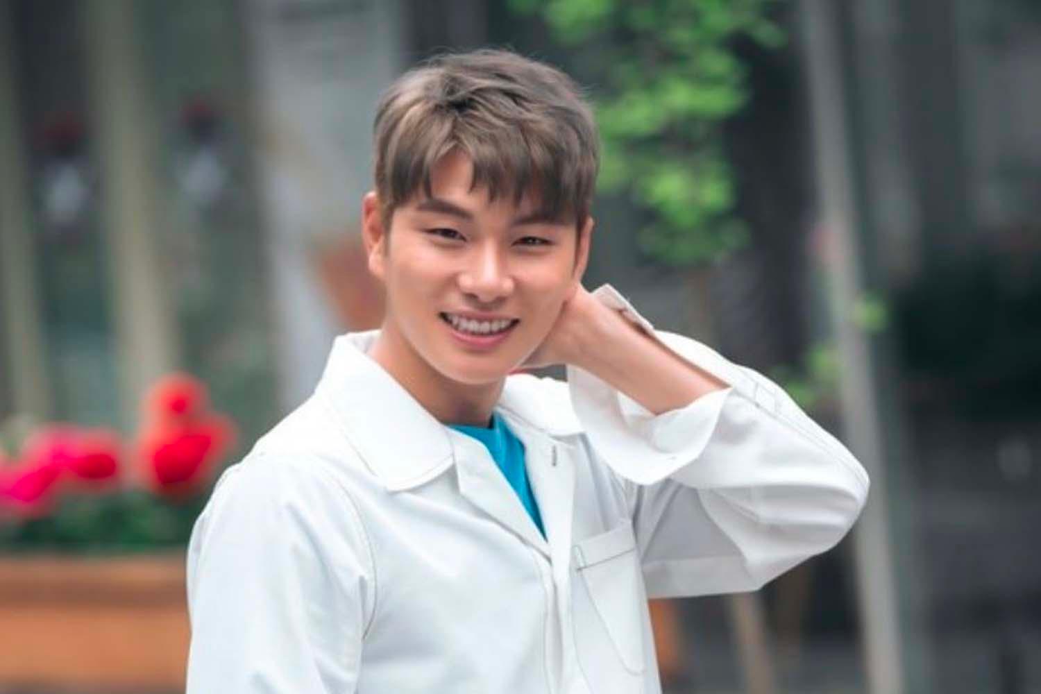 อีอีคยอง สวมชุดสูทสีดำ ขณะที่มือกำลังแสดงสัญลักษณ์นิ้วหัวใจเล็ก