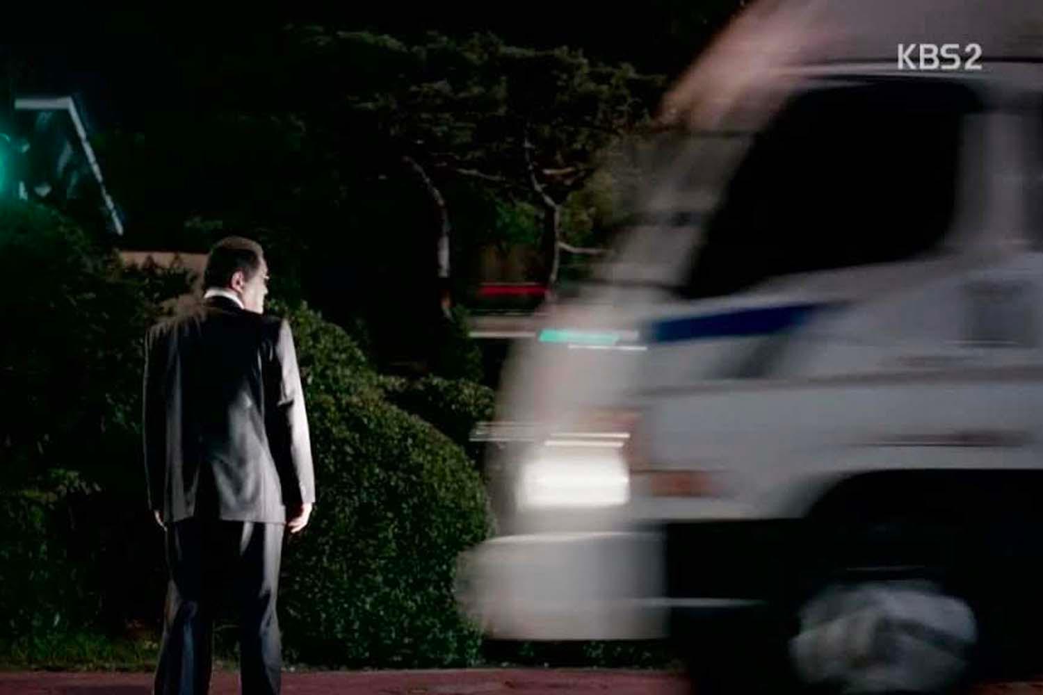 ฉากจากละครที่แสดงให้เห็นภาพชายคนหนึ่งยืนอยู่ตรงข้ามกับรถบรรทุกที่เคลื่อนผ่านอย่างรวดเร็ว