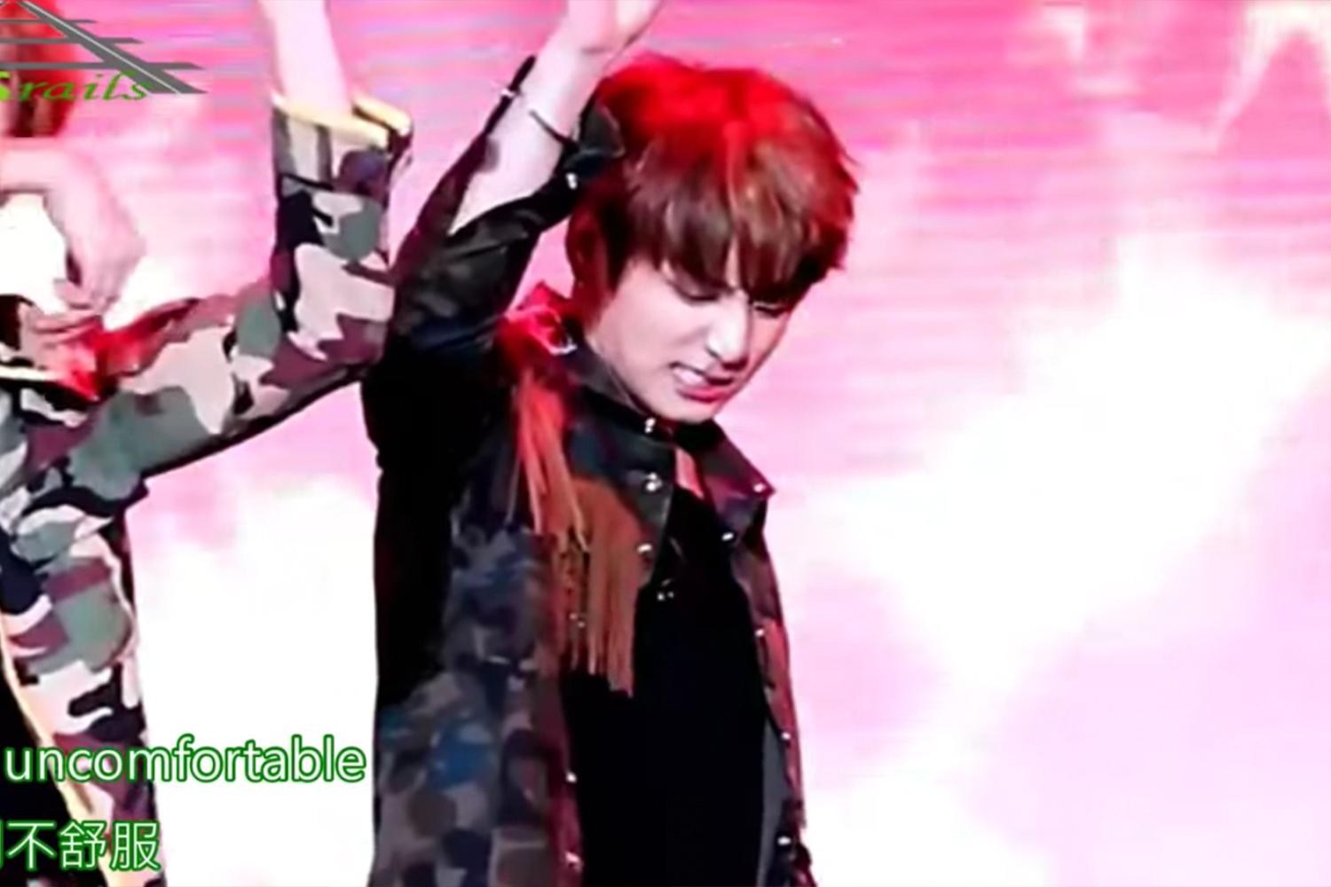 韓國舞台表演場景，歌手在動感燈光下揮舞雙手的瞬間。