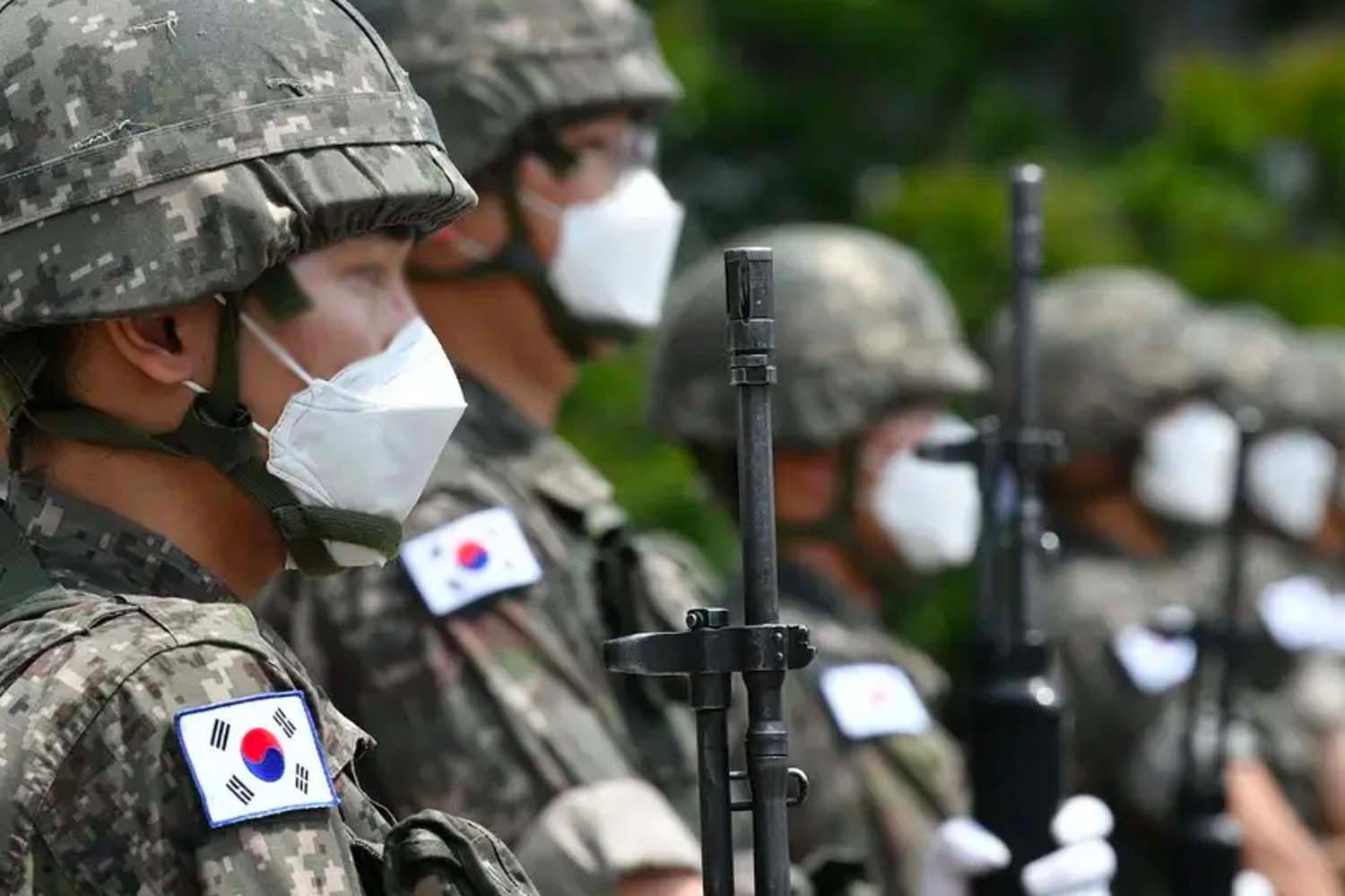 ทหารเกาหลีใต้ยืนเข้าแถวรับหน้าที่ในชุดเครื่องแบบพร้อมหน้ากากอนามัย