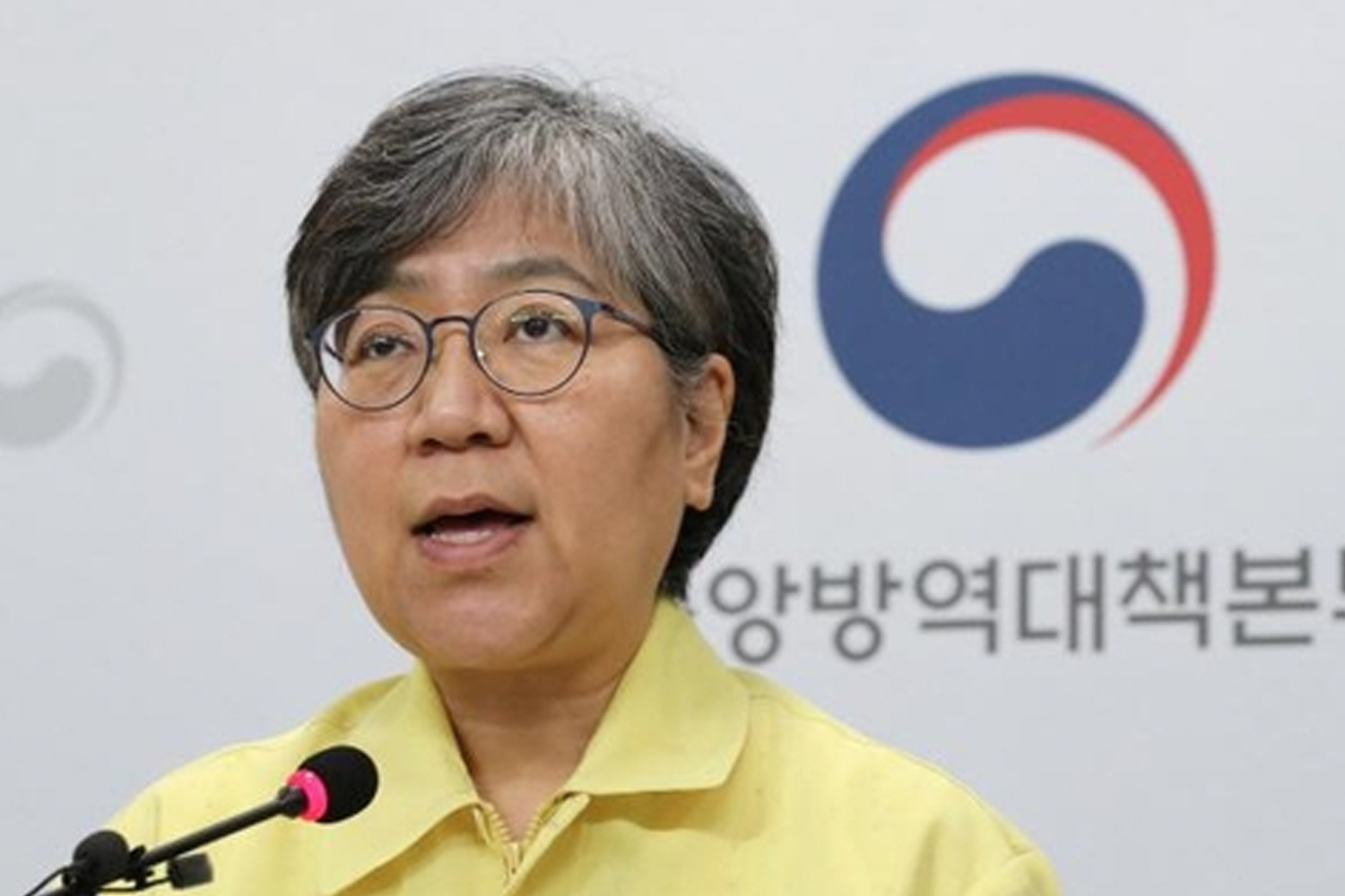 韓國疾病控制和預防機構的標誌和一位穿著防護夾克的官員,與新冠疫情信息發布有關的影像。