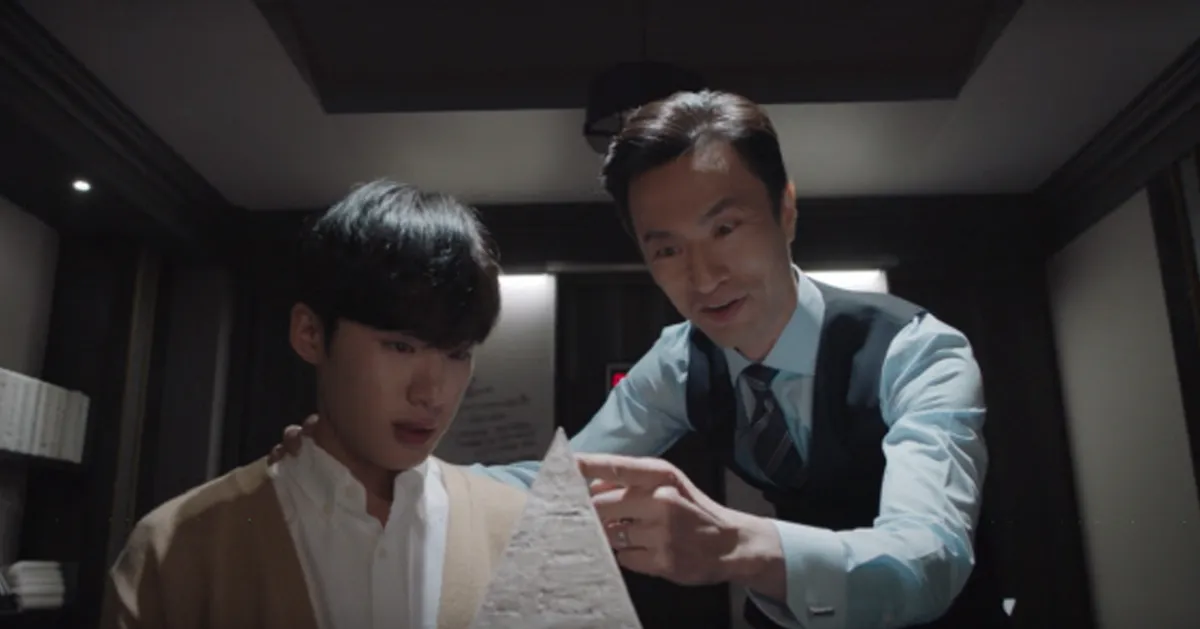 在一個室內場景中，兩個人參加某種會議或討論，顯示出與疫情相關的社交距離措施。