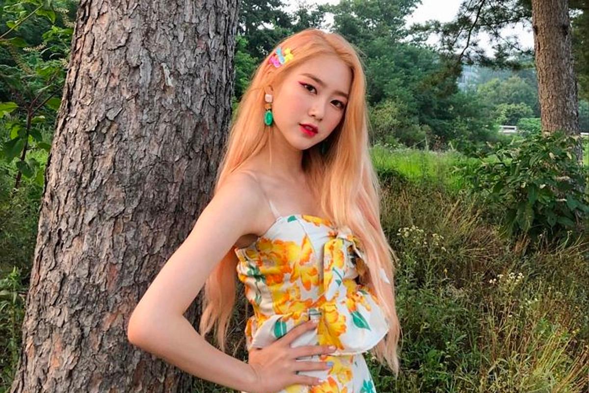 柔理站在樹前，身穿花卉連衣裙，洋溢著夏日氣息