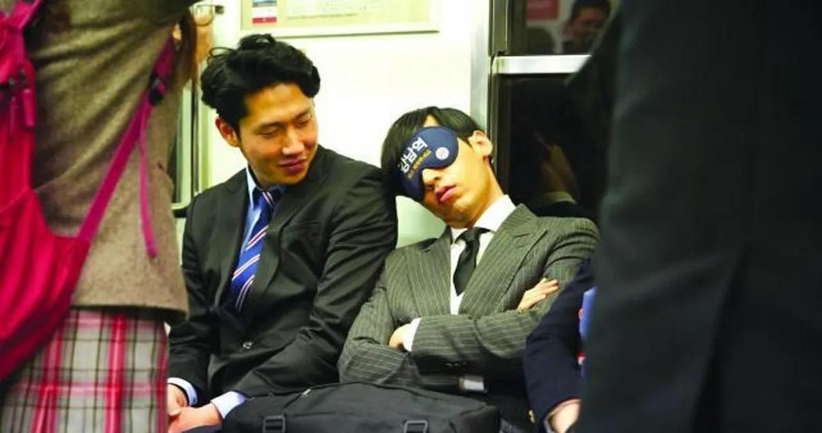 ผู้โดยสารในรถไฟใต้ดินของเกาหลีบางคนที่นั่งหลับหลังจากทำงานหนักกลางวัน