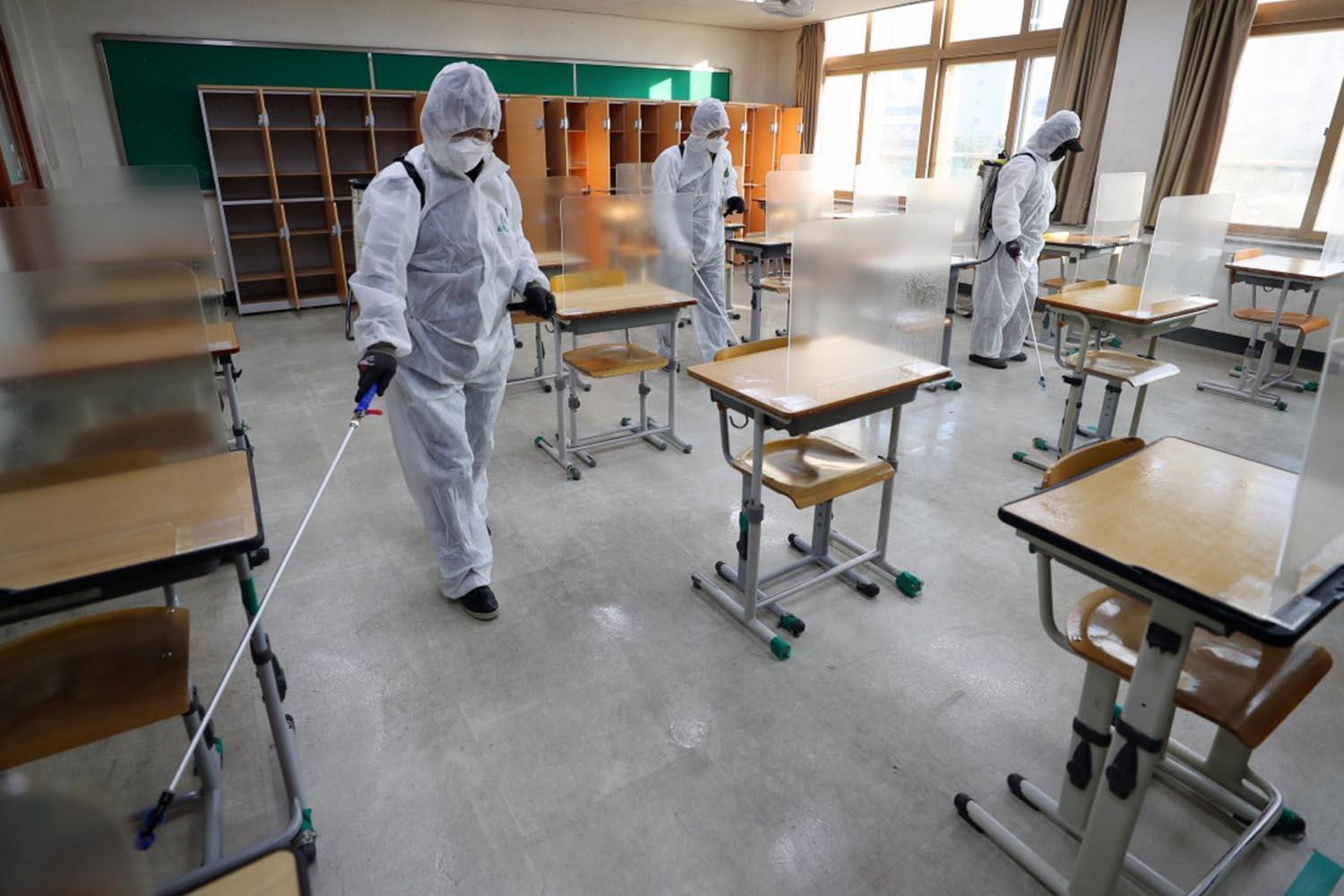 เจ้าหน้าที่กำลังทำความสะอาดและฆ่าเชื้อภายในห้องเรียน ด้วยโปรแกรมเตรียมพร้อมการสอบซูนึงท่ามกลางการระบาดของโควิด-19 ในเกาหลีใต้
