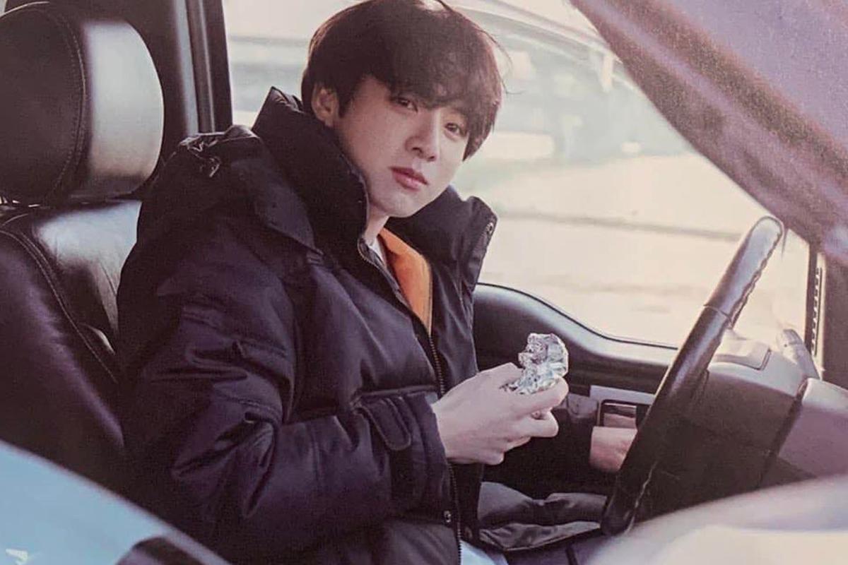 一個人在車內享用食物的場景，暗示國際駕照的重要性。