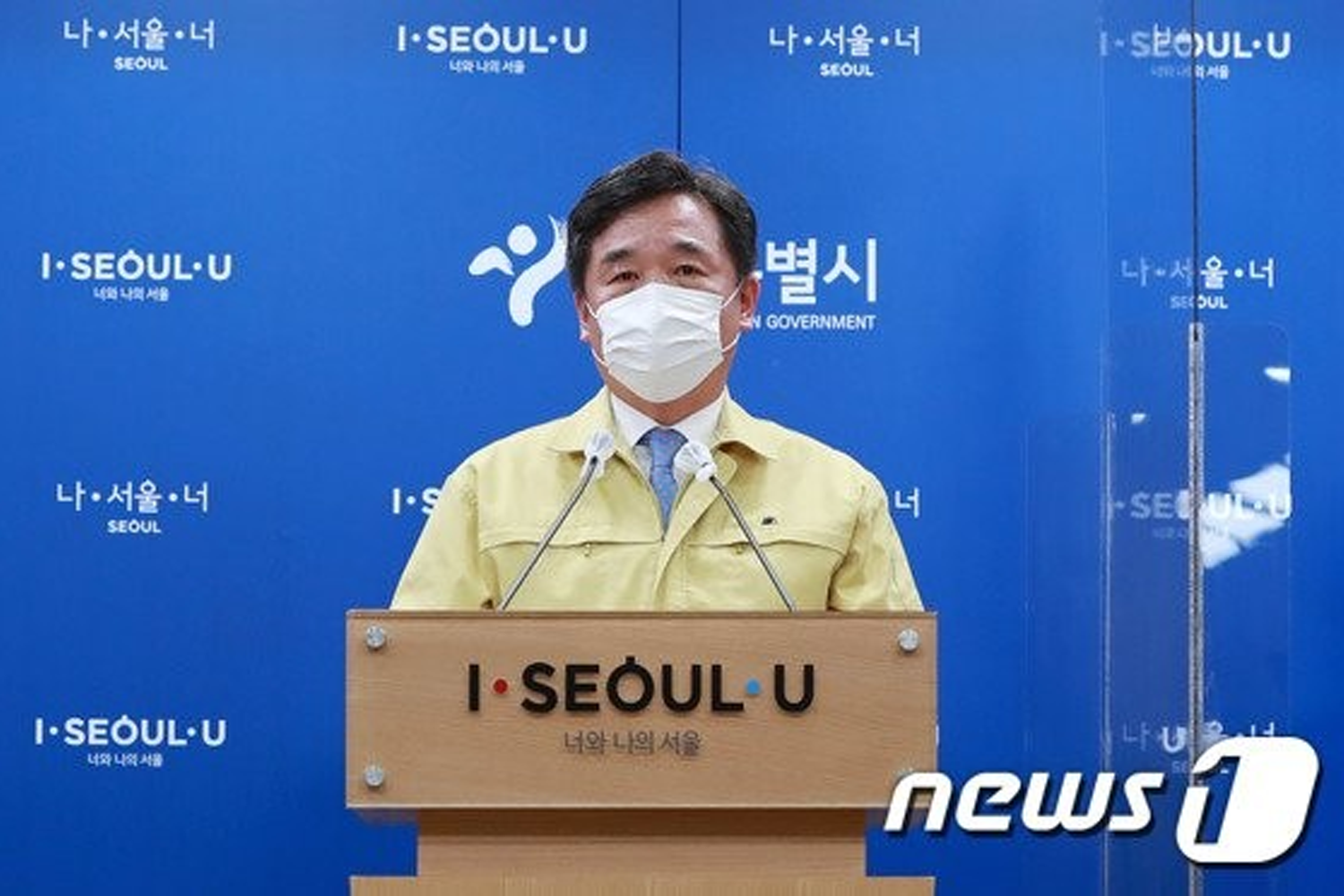 新聞發布會上，一名官員站在講台後，背景展示了首爾城市標誌。