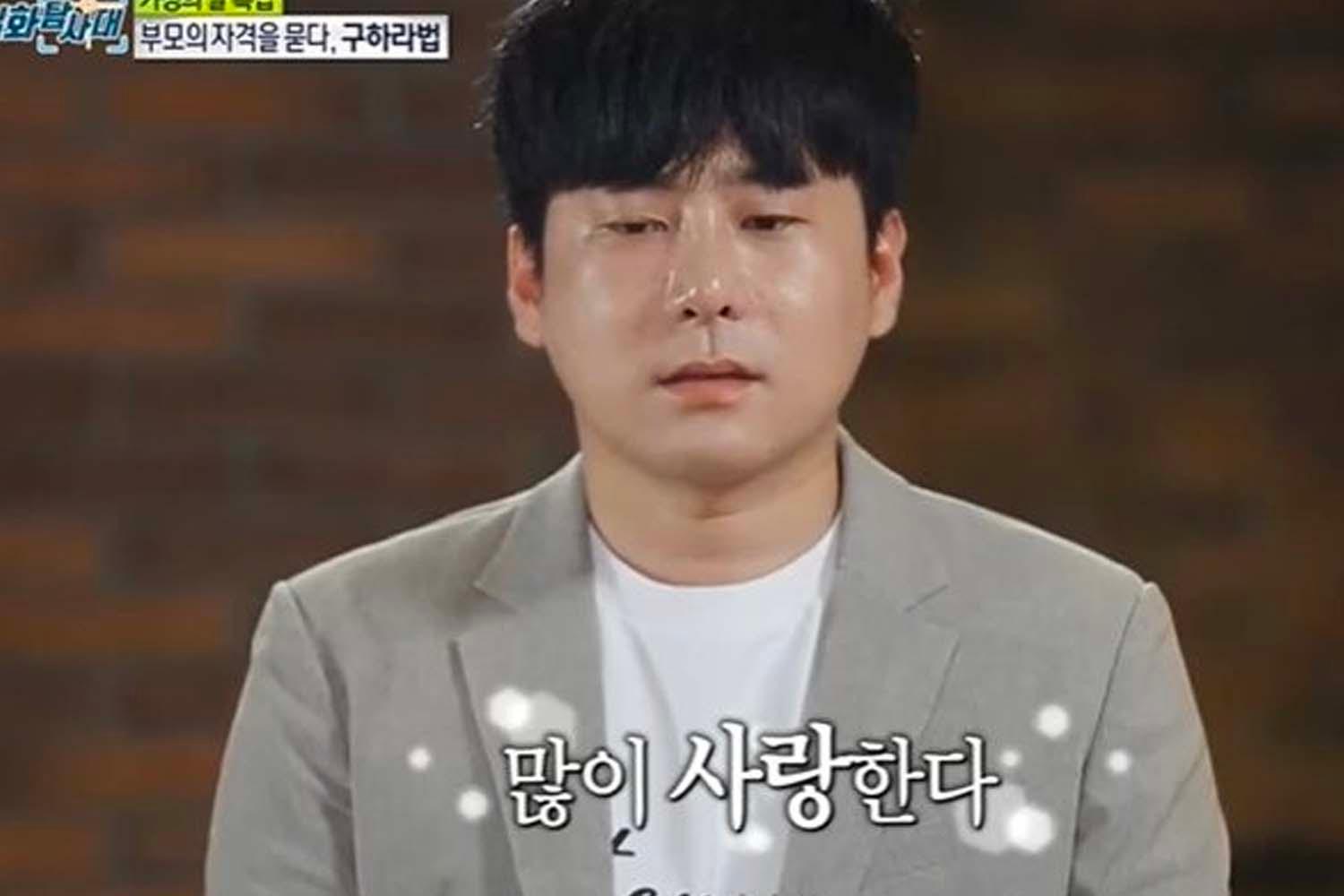 ชายใส่สูทถ่ายภาพในสตูดิโอ พร้อมตัวอักษรเขียนว่า '많이 사랑한다' ในรายการโทรทัศน์เกาหลี