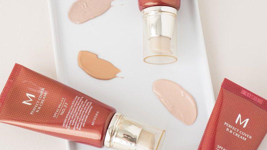 บีบีครีม M Perfect Cover ของแบรนด์ Missha วางอยู่บนถาดสีขาว พร้อมกับบีบครีมแสดงเฉดสีที่ต่างกันออกไป