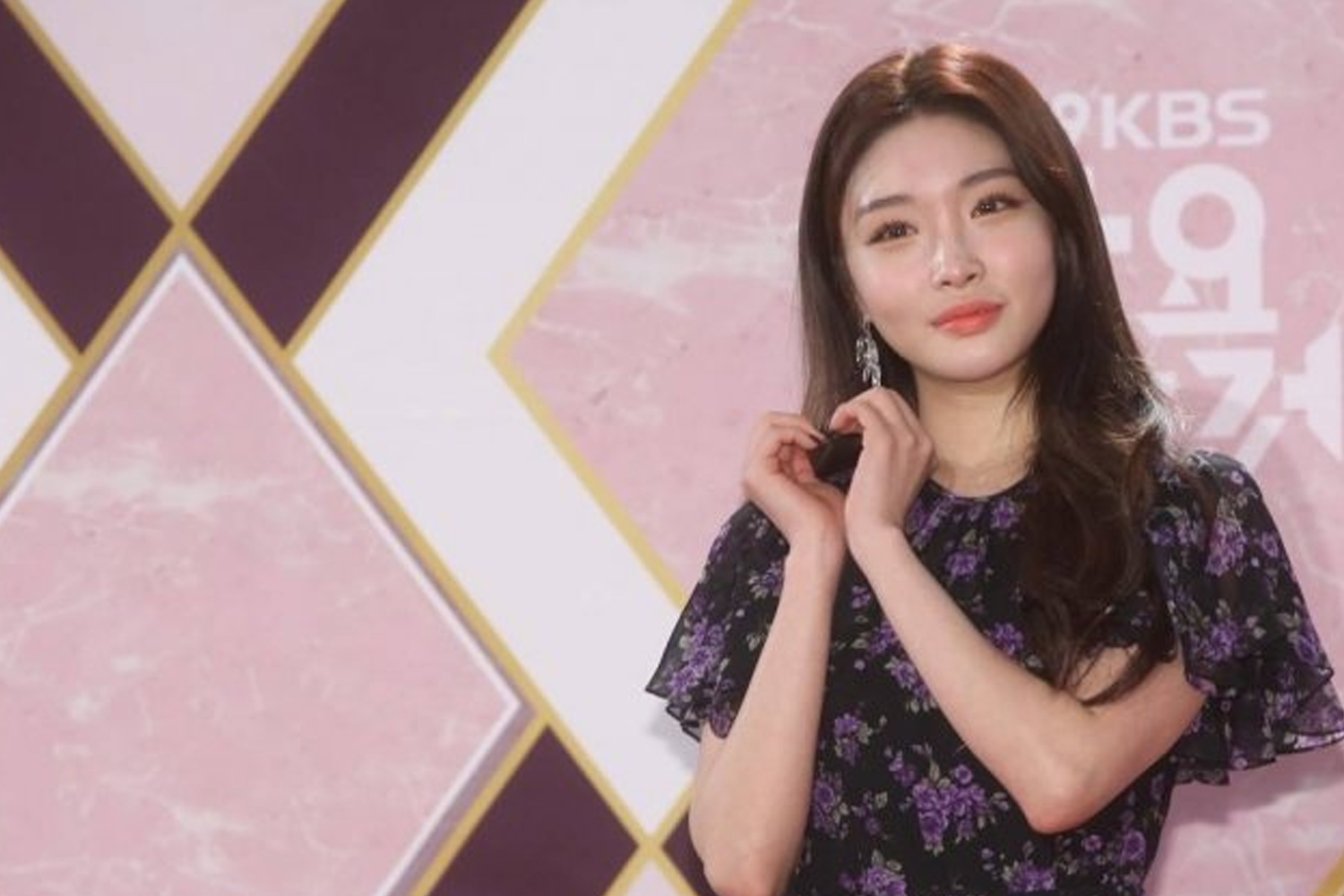 請夏出現在粉色背景前，穿著黑色圖案裙裝並擺出可愛手勢。這位韓國女歌手在投票結果中排名第4位。