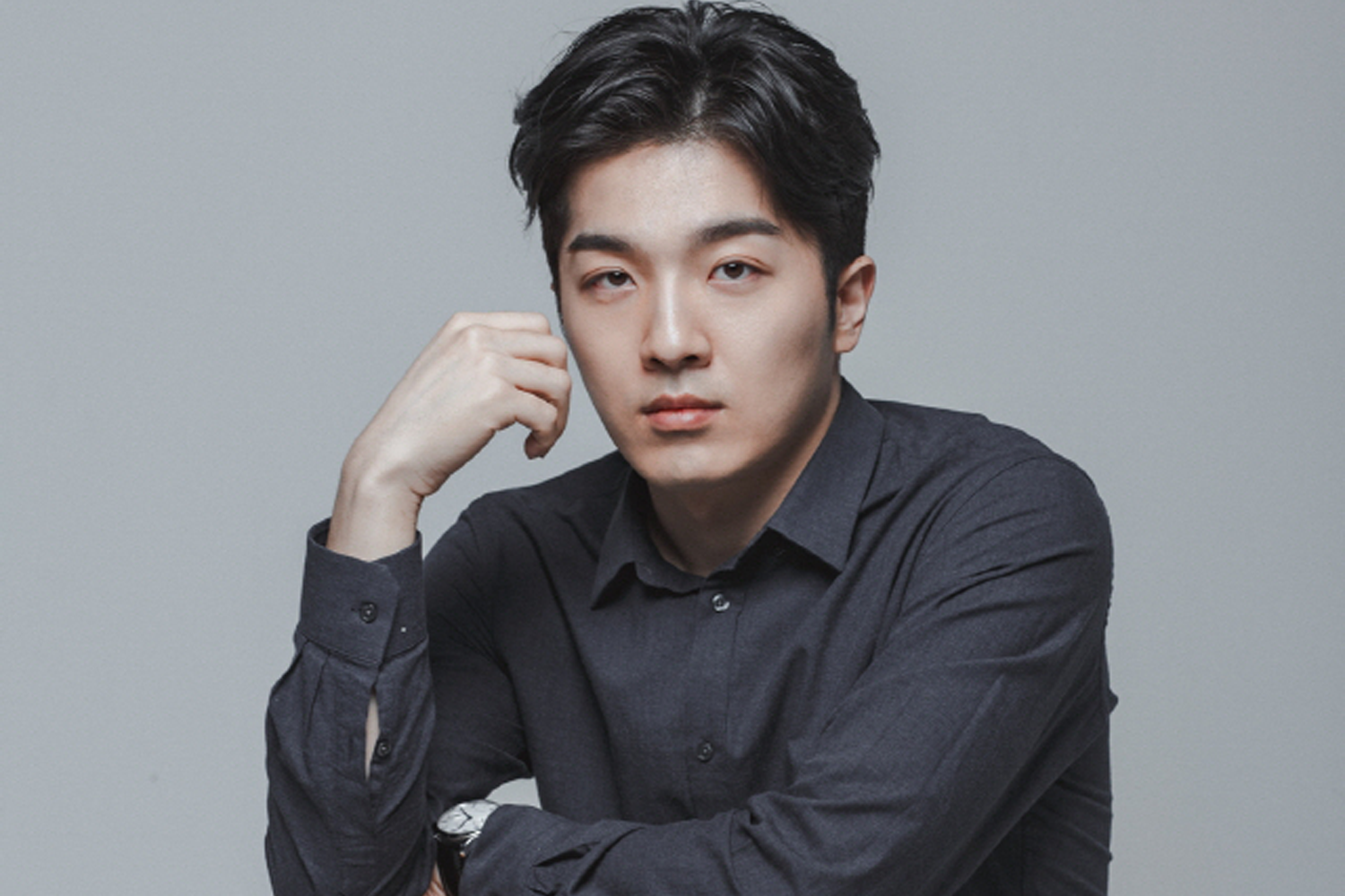 Jukjae身穿黑色襯衫，雙手放在下巴前，展現温暖沉穩的形象。這位韓國吉他手在投票結果中排名第8位。