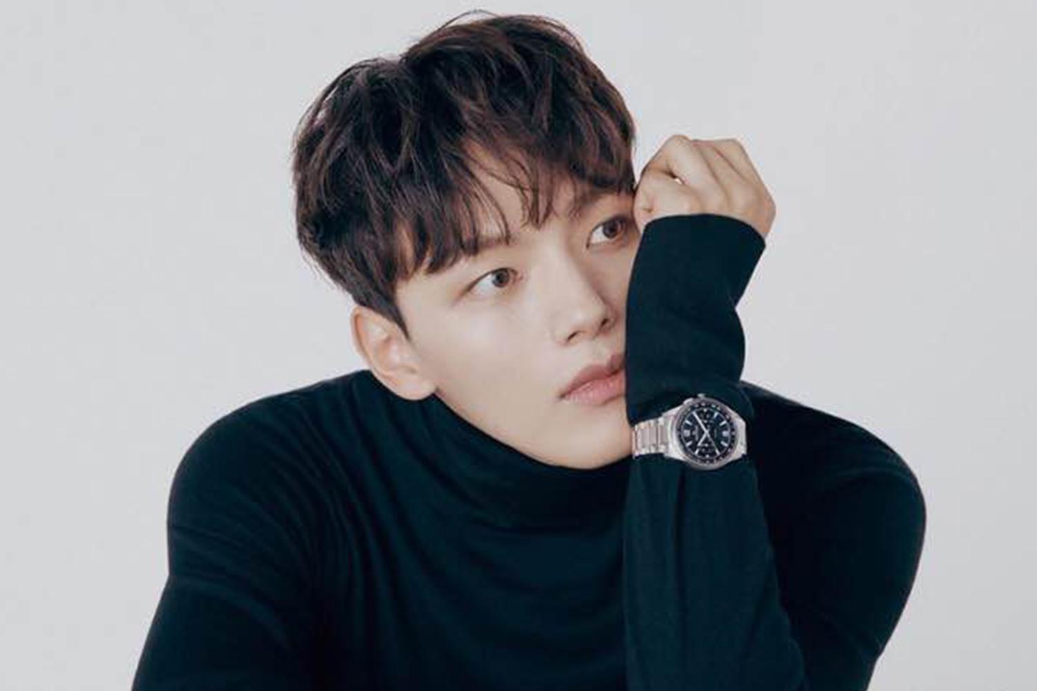 韓國男明星呂珍九身穿黑色衣服，手腕上戴著銀色手錶，屏住鼻子的一半。