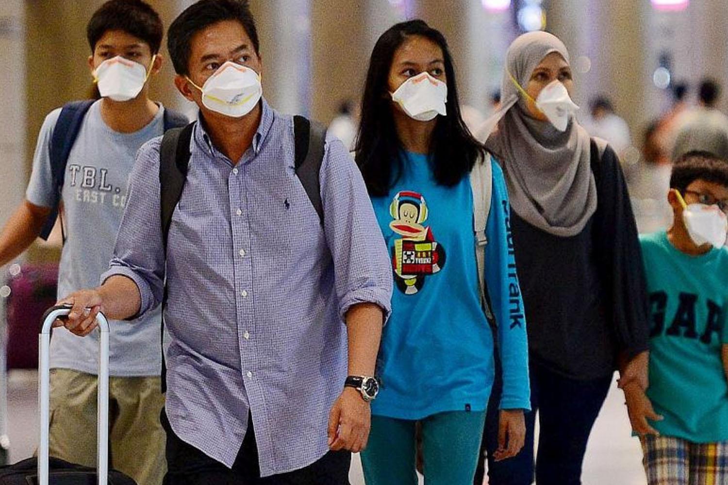 Turisti con valigie passeggiando in un aeroporto, indossando abbigliamento casual e abiti tradizionali.