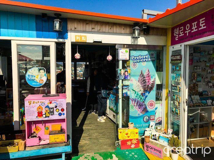 Ice cream shop with colorful decorations and signs in Dongpirang Mural Village, Tongyeong.