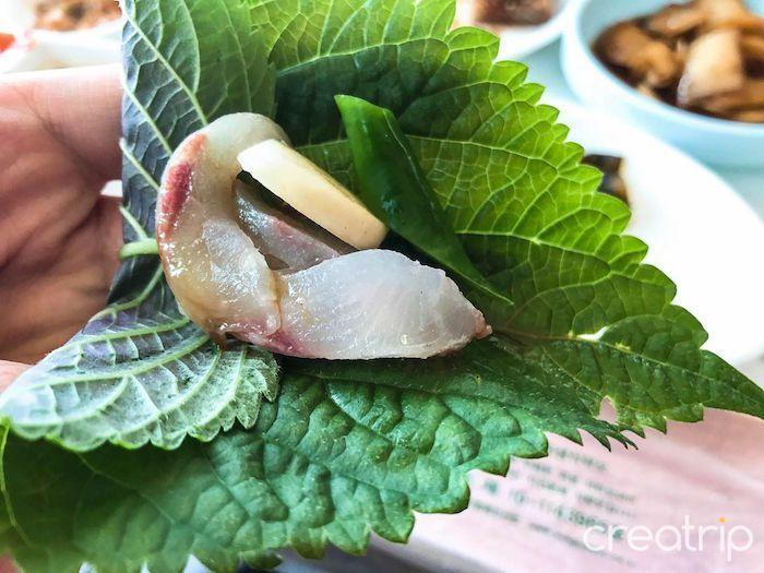 Fresh perilla leaf with Korean sashimi ready for wrapping and tasting.