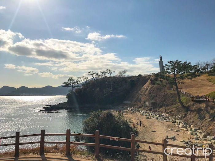 Scenic coastal view in Lee Sunshin Park with clear water and rocky beach area.