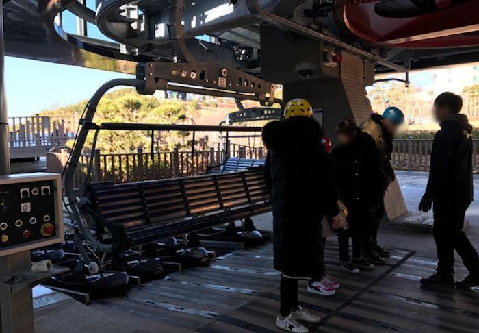 Group of people standing around the boarding area for Tongyeong cable car.