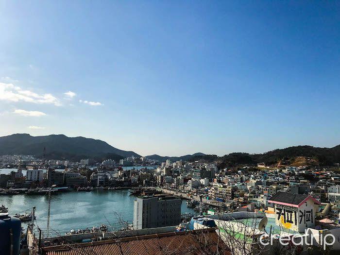 Panoramic daytime view of Tongyeong city with buildings and water visible from an elevated location.