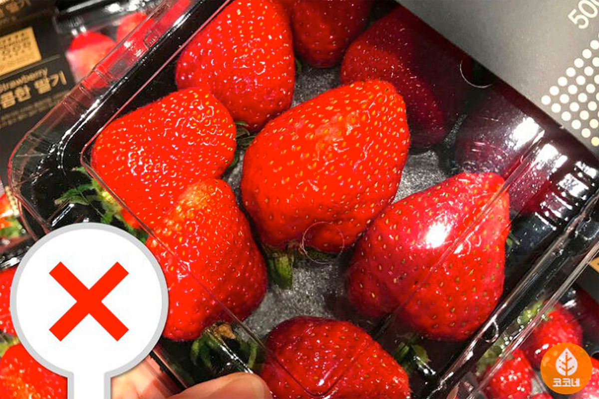 不均勻大小的士多啤梨在盒內，展示需要避免挑選的健康不佳果實。