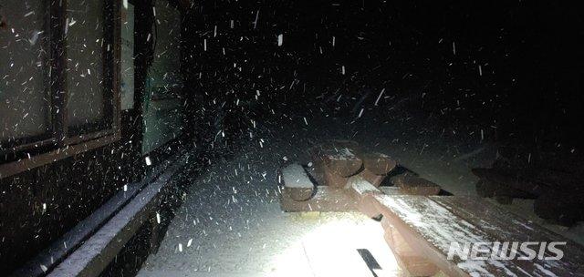 หิมะแรกของกรุงโซลตกในช่วงเวลากลางคืน ภาพแสดงหิมะตกลงมายังพื้นที่โซลอย่างเห็นได้ชัดเจน สถานที่ได้รับแสงไฟส่องแสงผ่านในมุมต่ำ ทำให้หิมะแรกที่ตกในกรุงโซลโดดเด่นและสวยงาม