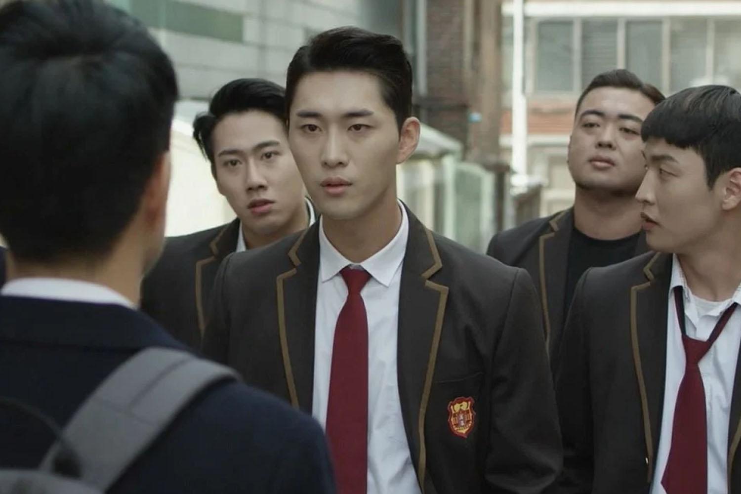 กลุ่มนักเรียนชายในชุดเครื่องแบบเดินตามถนนในประเทศเกาหลี