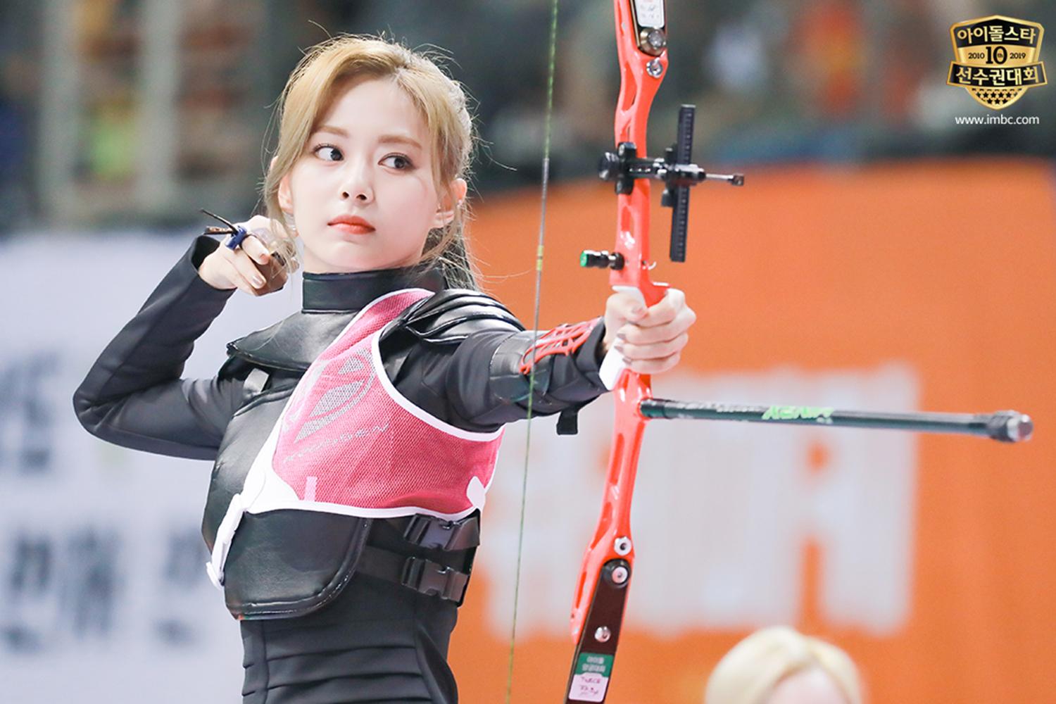 女性韓星正在準備射箭,以專業姿勢瞄準目標,展示驚人的運動技能。